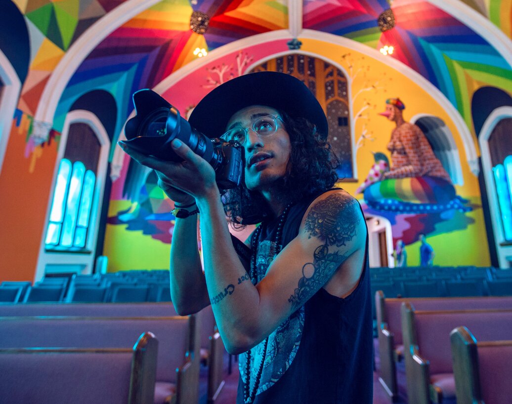 Person holding a camera in a colorful room