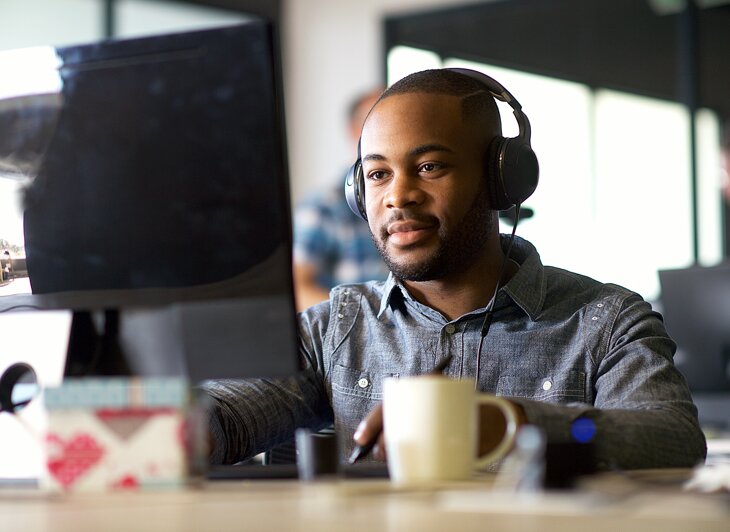 Man with headphones working at a computer