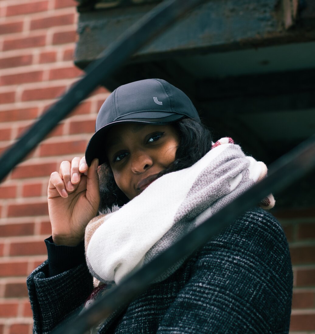 Woman in a hat and scarf smiling